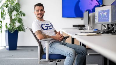 male gea employee relaxing at desk in front of computer