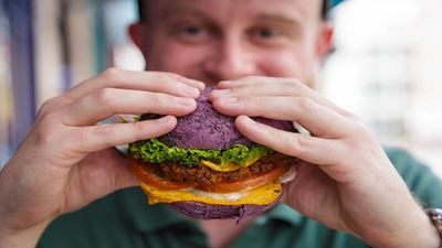 Uomo che mangia un burger vegano