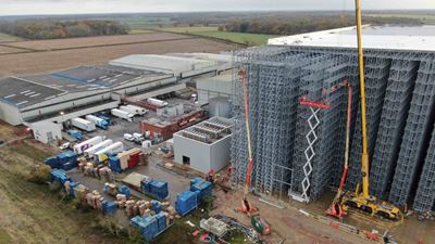 Photo 3: The photo shows the rear of the high-bay warehouse, where the evaporators are standing on a rack 40 meters above the ground at the time of the photo shoot. These were lifted up by crane a few weeks later. The adjacent building shows the three condensers on the roof of the GEA machine room (Photo: Magnavale).